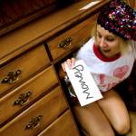 girl under a desk in a thrift store finding an envelope of money